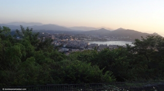 El mirador desde la antigua estación y las vistas desde el albergue donde la vegetación oculta el barrio de Gros.